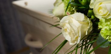 A coffin with a flower arrangement in a morgue